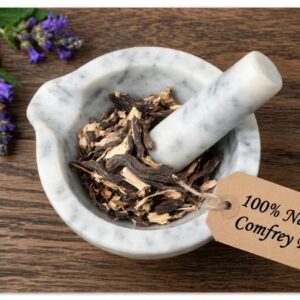Comfrey root powder, organic, in a mortar and pestle with Symphytum officinale plant background - The Herb Peddler