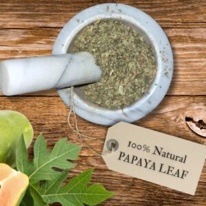 Papaya leaf dried in a mortar and pestle with Carica papaya plant background - The Herb Peddler