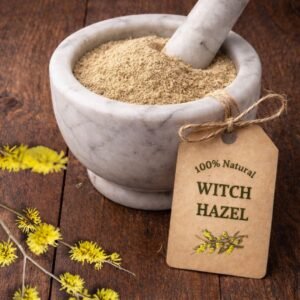 Witch Hazel dried herb in a mortar and pestle with Hamamelis virginiana plant background - The Herb Peddler