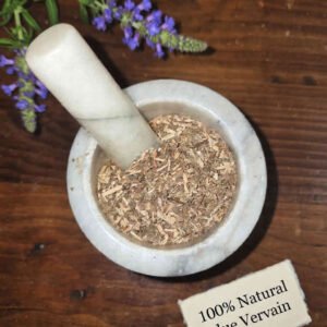 Blue Vervain dried herb in a mortar and pestle with Verbena hastata plant background - The Herb Peddler