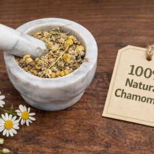 Chamomile dried flowers in a mortar and pestle with Matricaria chamomilla plant background - The Herb Peddler