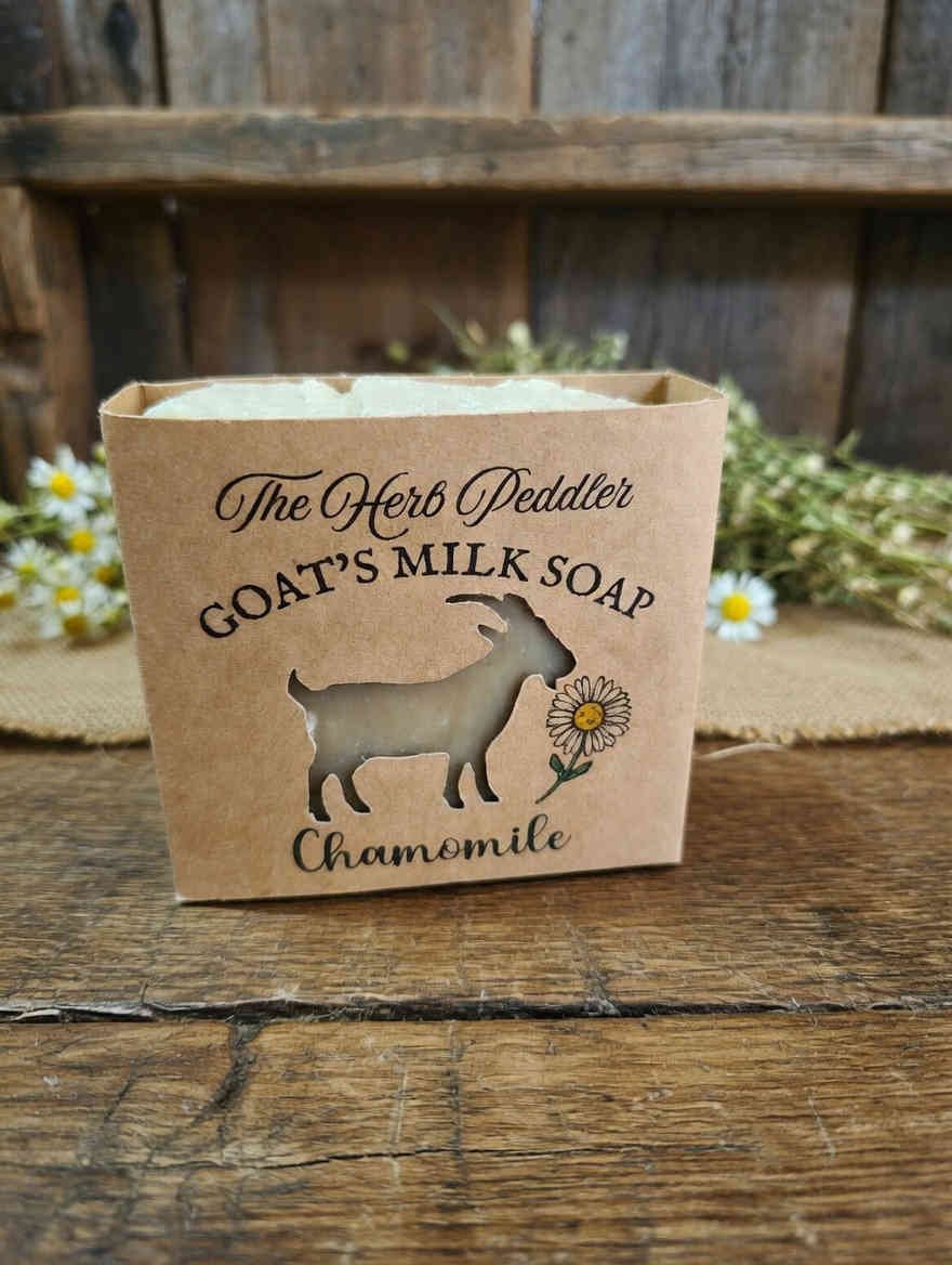 Rustic hot-process Chamomile Goat's Milk Soap bar with real chamomile flowers on top, displayed with dried chamomile blossoms - The Herb Peddler