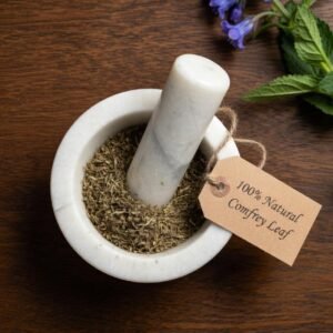 Comfrey leaf dried in a mortar and pestle with Symphytum officinale plant background - The Herb Peddler
