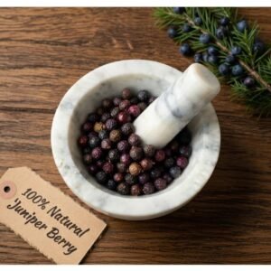 Juniper berries dried in a mortar and pestle with Juniperus communis branch background - The Herb Peddler